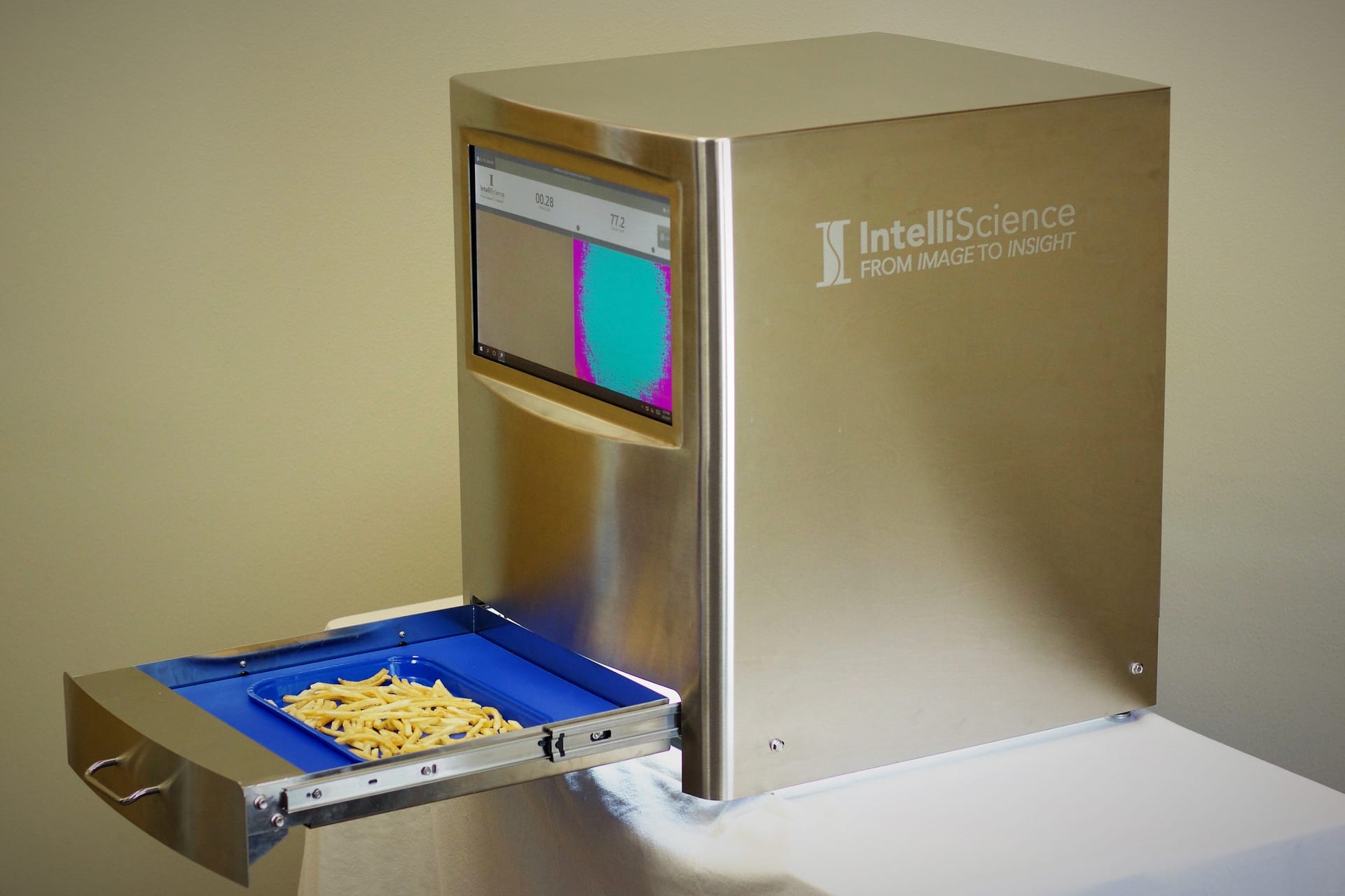 The IntelliScience Appliance standing on its own on a counter with no conveyor, its sample tray drawn out holding a sample and a result on its touchscreen.