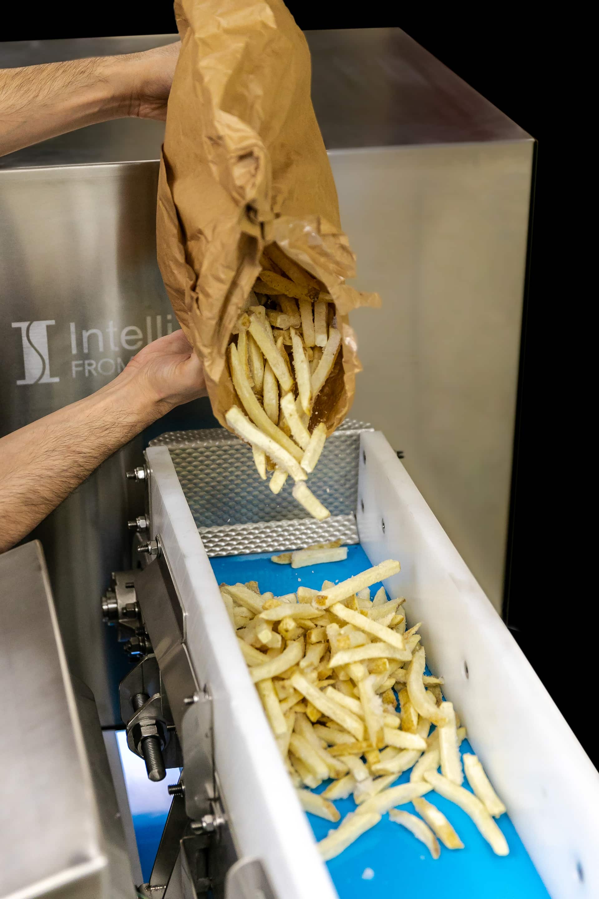 Hands pouring a produce sample from a bag into the iVIA sample tray.